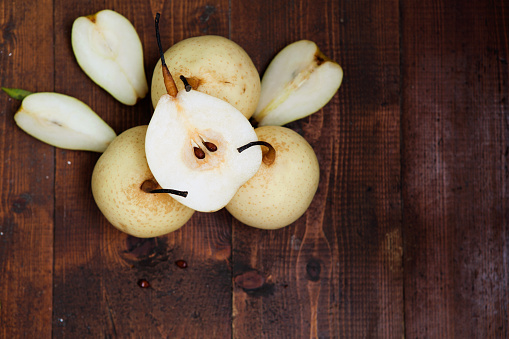 Fresh ripe organic pears on a rustic wooden table, top view
