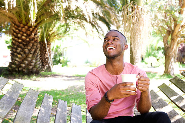 Young african man relaxing outdoors with a cup of coffee