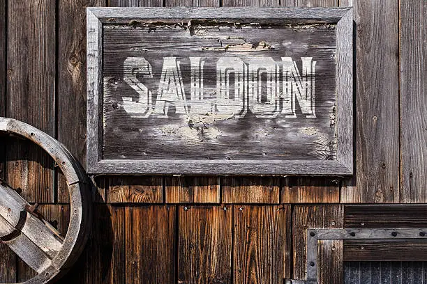 wooden sign with word saloon, planks on the background, vintage style