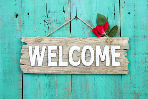 Welcome sign with red rose bud