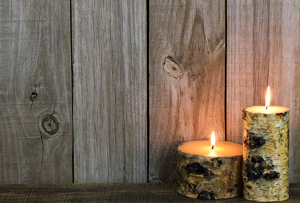 Log candles burning by wood background