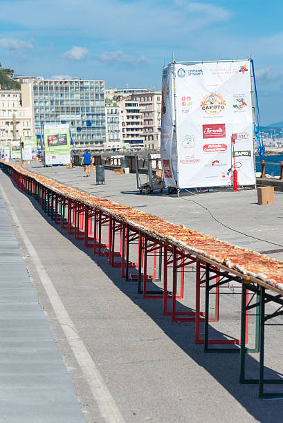 Guinnes World record pizza long 2 km Naples, Italy - May 18, 2016:Naples beat the Guinness world record for long pizza margherita circa 2 Km exposed on the waterfront. The super pizza of about 1,850 meters, exceeding the previous record of 1,595 meters, reached June 20, 2015 at Expo in Milan. guinnes stock pictures, royalty-free photos & images