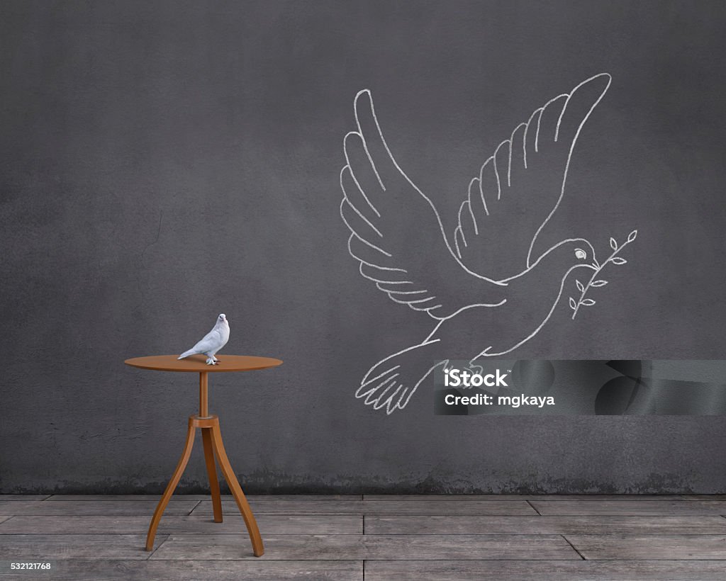 Dream of Dove: Being a Dove of Peace White dove (or pigeon) on a coffee table with wooden floor and dove carrying an olive branch sketched (chalk drawing) on the wall. Dove - Bird Stock Photo