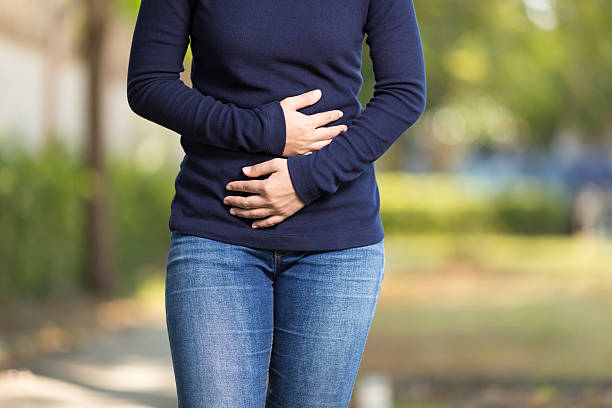 Woman Has Stomach Ache at Park Woman Has Stomach Ache at Park digestive system photos stock pictures, royalty-free photos & images