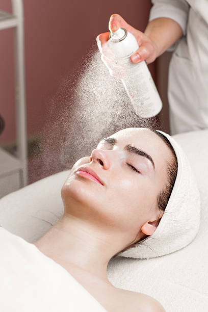 istock serum mask spraying from can on young woman's face 532128220