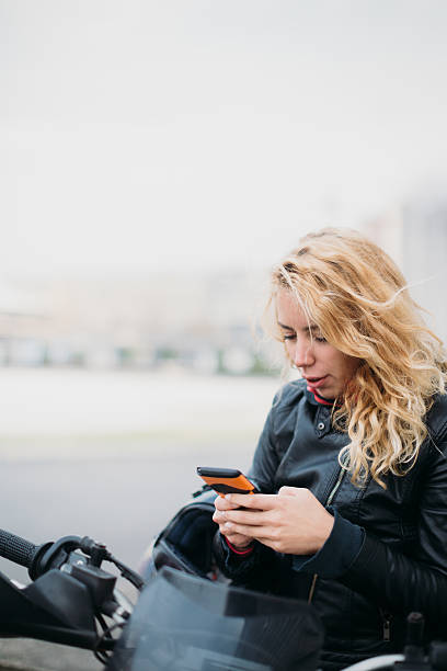 istock Woman at motorcycle using mobile phone 532128452