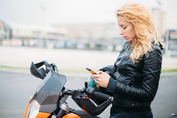 istock Woman at motorcycle using mobile phone 532128800