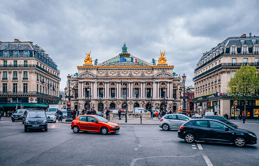 Paris, France - April 25, 2016: Front view of the Opera National de Paris with city traffic and people. The Palais Garnier is an opera house built from 1875 for the Paris Opera