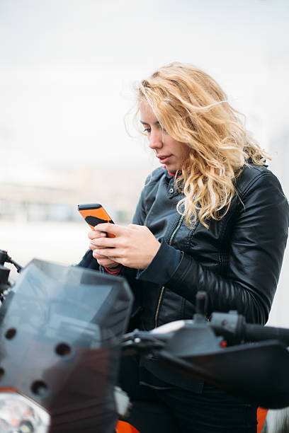istock Woman at motorcycle using mobile phone 532129176