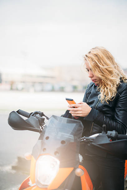 istock Woman at motorcycle using mobile phone 532129278