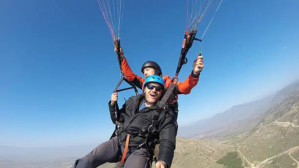 Photo of Tourist playing paragliding guided by a pilot