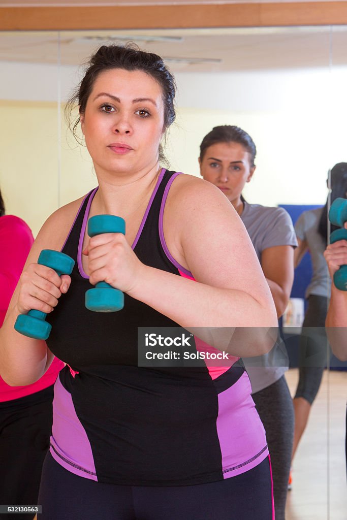 Womens Gym Fitness Class Using Weights Women Taking Part In Gym Fitness Class Using Weights 20-29 Years Stock Photo