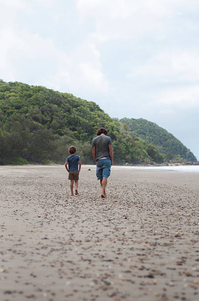 istock Father and son walking on the beach 532130605