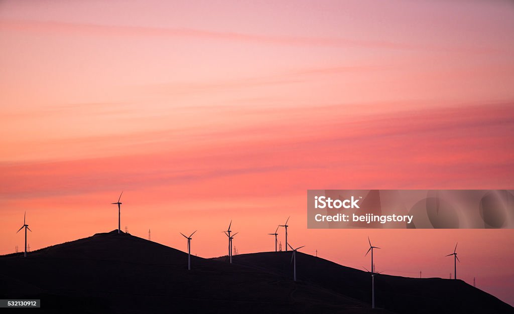 wind turbines against red and orange sunset Wind Stock Photo