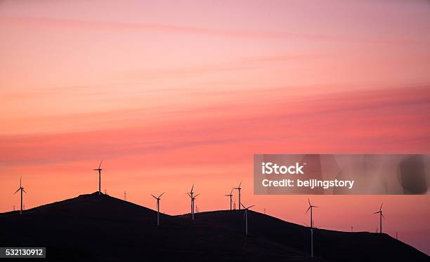 Wind Turbines Against Red And Orange Sunset Stock Photo - Download Image Now - Wind, Back Lit, Carbon Footprint