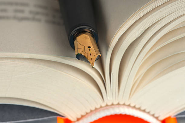 istock Close-up of open book and pen. 532131756