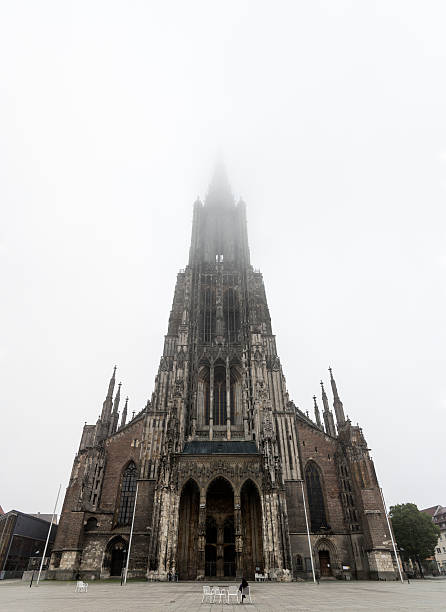 Ulm Munster A woman sitting on a chair and looking at the Ulmer Munster (Ulm Cathedral) in fog; the tallest medieval church in the world. Ulm, Baden-Wurtemberg, Germany. ulm minster stock pictures, royalty-free photos & images