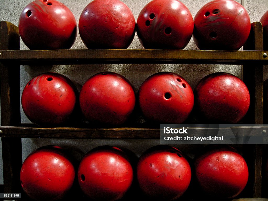Red Bowling Balls Twelve red bowling balls on a very old bowling ball rack. 2015 Stock Photo