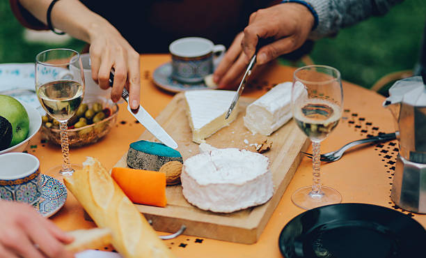 amici di mangiare nel giardino periferia di parigi - forma di formaggio foto e immagini stock