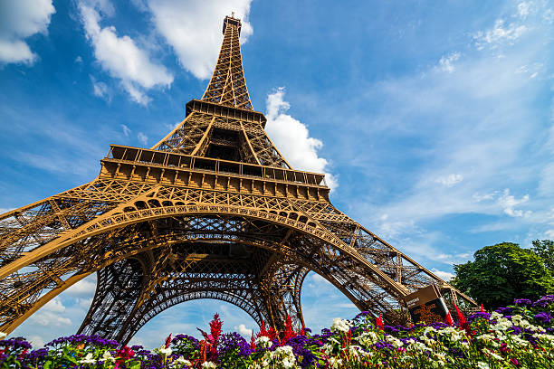 Wide shot of Eiffel Tower with dramatic sky and flowers Wide shot of Eiffel Tower with dramatic sky and flowers at late evening, Paris, France Paris Right Bank stock pictures, royalty-free photos & images