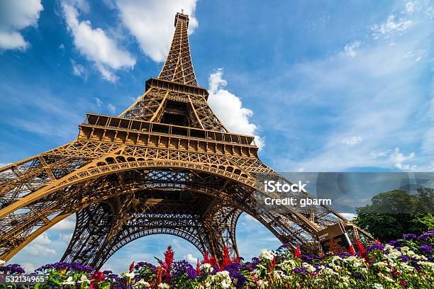 Wide Shot Of Eiffel Tower With Dramatic Sky And Flowers Stock Photo - Download Image Now
