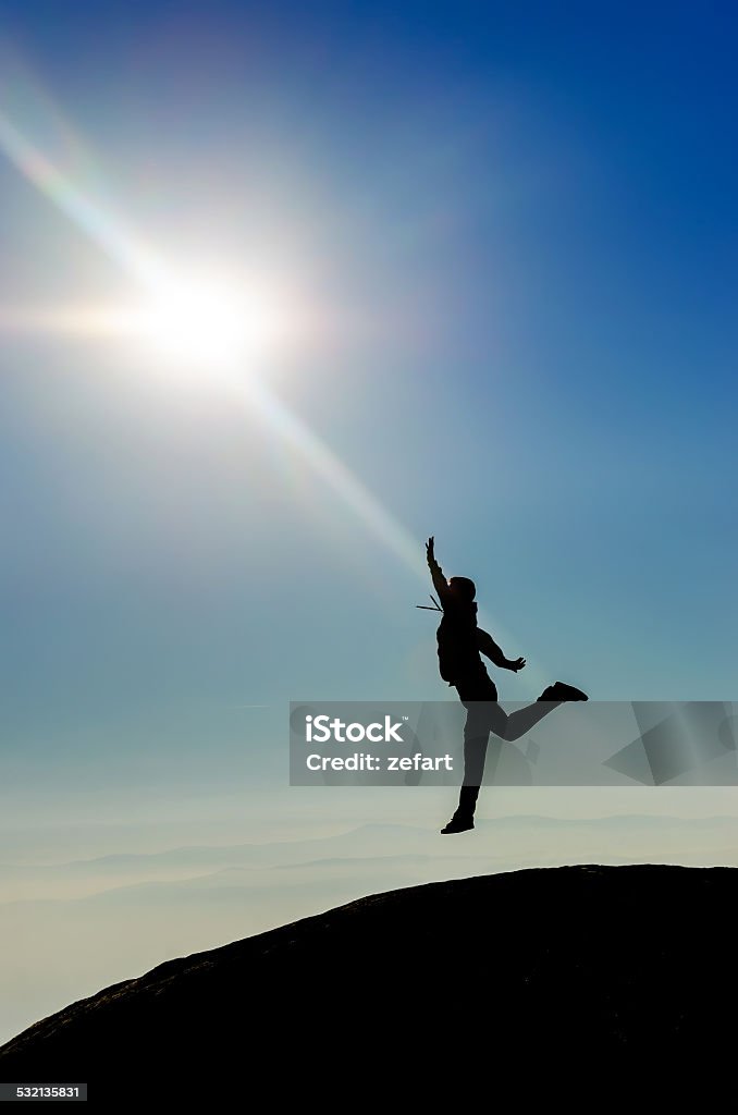 HEAVEN. Man Silhouette jumping reaching the sun HEAVEN. Man Silhouette jumping reaching the sun at the top of the world. High mountain range Child Stock Photo