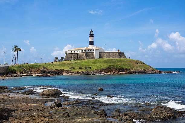 View of Farol da Barra in Salvador, Bahia, Brazil View of famous Farol da Barra (Barra Lighthouse) in Salvador da Bahia, Brazil. local landmark stock pictures, royalty-free photos & images