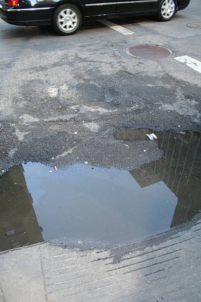 istock Puddle in street with Car 532137477