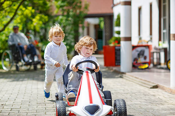 istock Two happy sibling boys playing with toy car 532147977