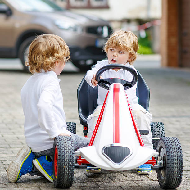 istock Two happy sibling boys playing with toy car 532147981