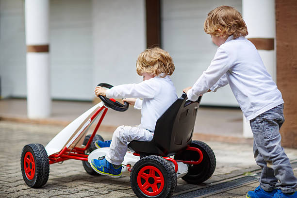 istock Two happy sibling boys playing with toy car 532147985