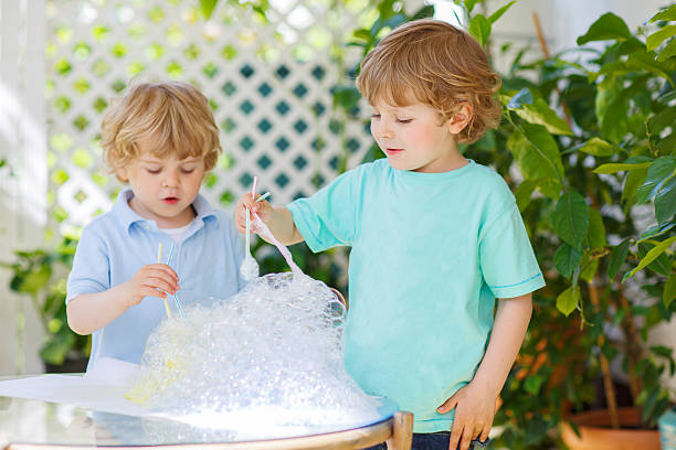 istock Two cute friend boys making experiment with colorful bubbles 532149017