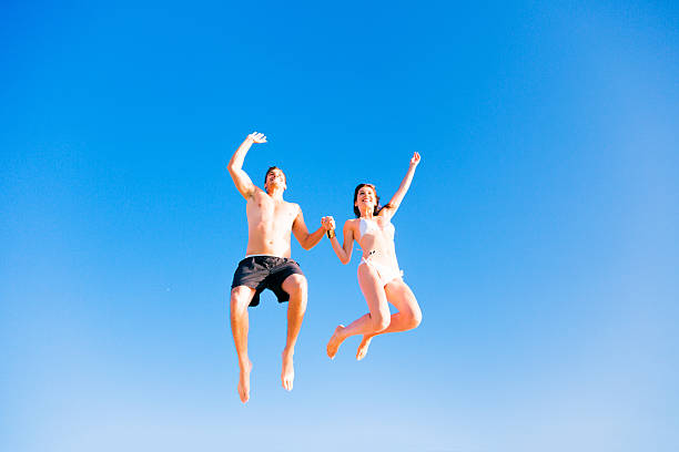 istock young couple in swimwear jumping 532150549