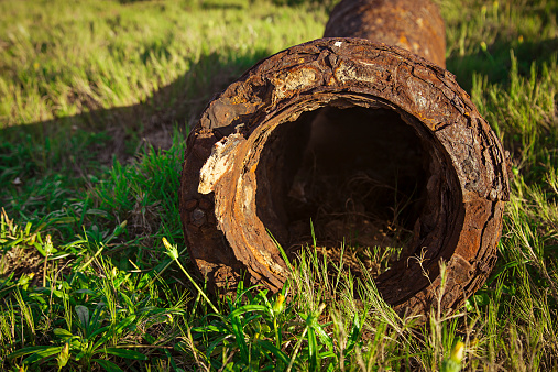 Old Rusted Sewer pipe, lying in Ruin on coastal grass