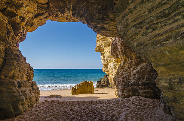 Cave at Beliche Beach Ocean view from the cave at Praia do Beliche hiding place stock pictures, royalty-free photos & images