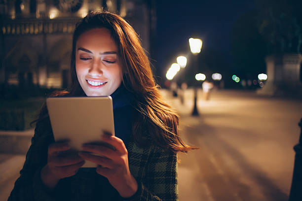 istock Young woman using digital tablet on street by night 532163990