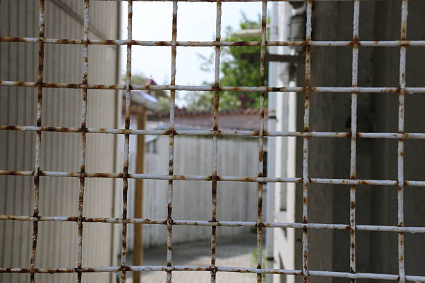 istock Old rusty fence with buildings in background 532165366