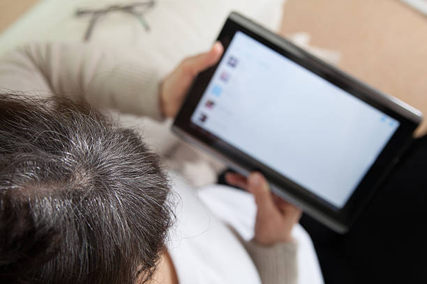 istock Mature good looking woman searching in internet on tablet device 532167769