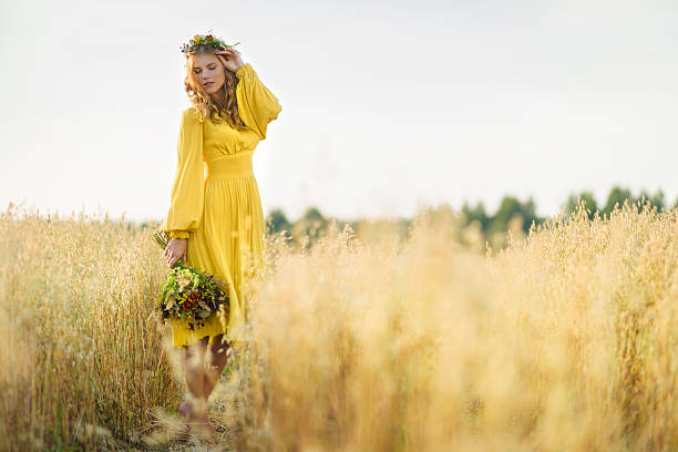 Happy woman in fields Happy young beautiful woman wearing flower garland in fields. blond hair fine art portrait portrait women stock pictures, royalty-free photos & images