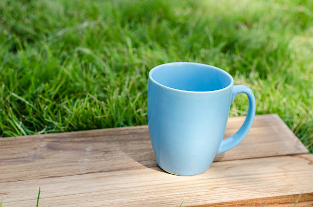 istock Blue mug on wooden board with green grass space. 532168501