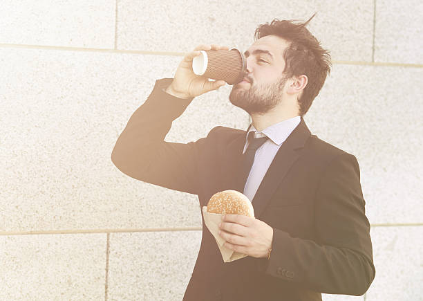 istock Businessman eating and drinking on to go 532169022