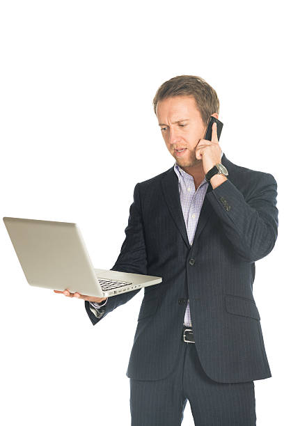 istock handsome man speaks on the mobile phone holding laptop 532169536