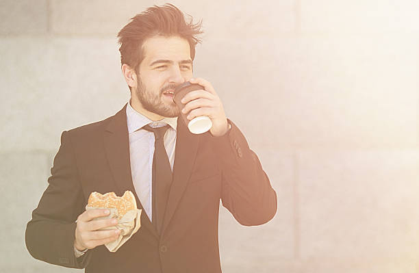 istock Businessman eating and drinking on to go 532169662