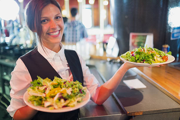 istock Pretty barmaid holding plates of salads 532169813