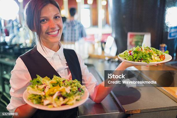 Pretty Barmaid Holding Plates Of Salads Stock Photo - Download Image Now - Food And Drink Industry, Waitress, Day