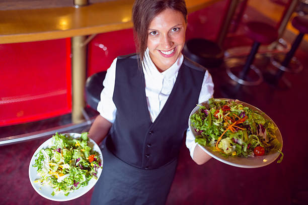 istock Pretty barmaid holding plates of salads 532169819