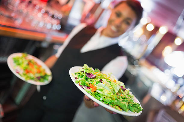 istock Pretty barmaid holding plates of salads 532169973