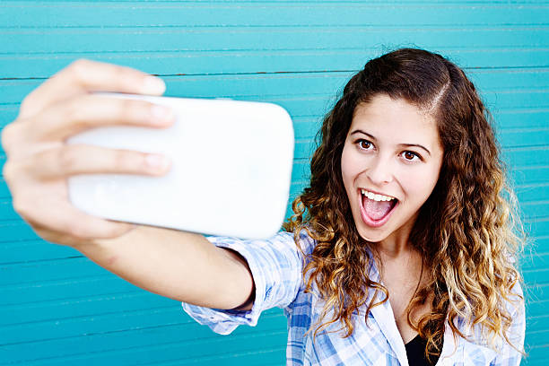 istock Exaggerated smile from pretty teenager taking Selfy by wall 532170863