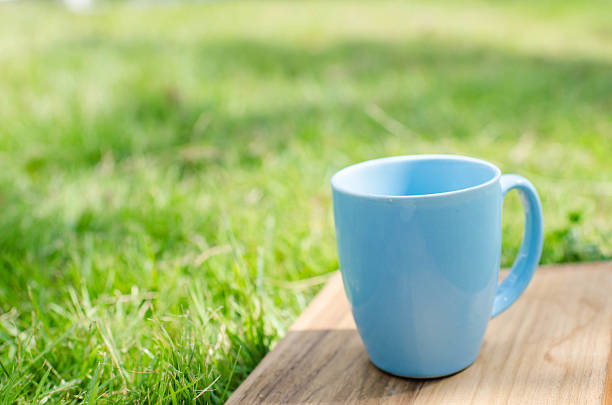 istock Blue mug on wooden board with green grass space. 532171519