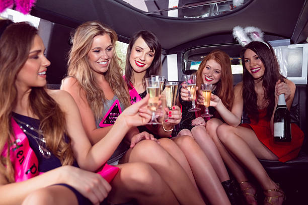 glückliche freunde trinken champagner in limousine - bachelorette party stock-fotos und bilder